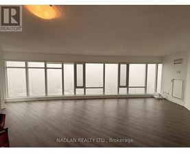 A room with a large window and wooden flooring.