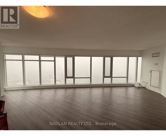 A room with a large window and wooden flooring.