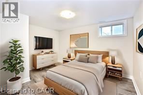 A bedroom with a bed, nightstand, and a plant.