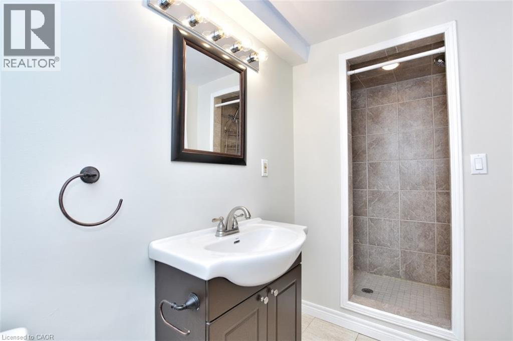 A bathroom with a sink, mirror, and shower.