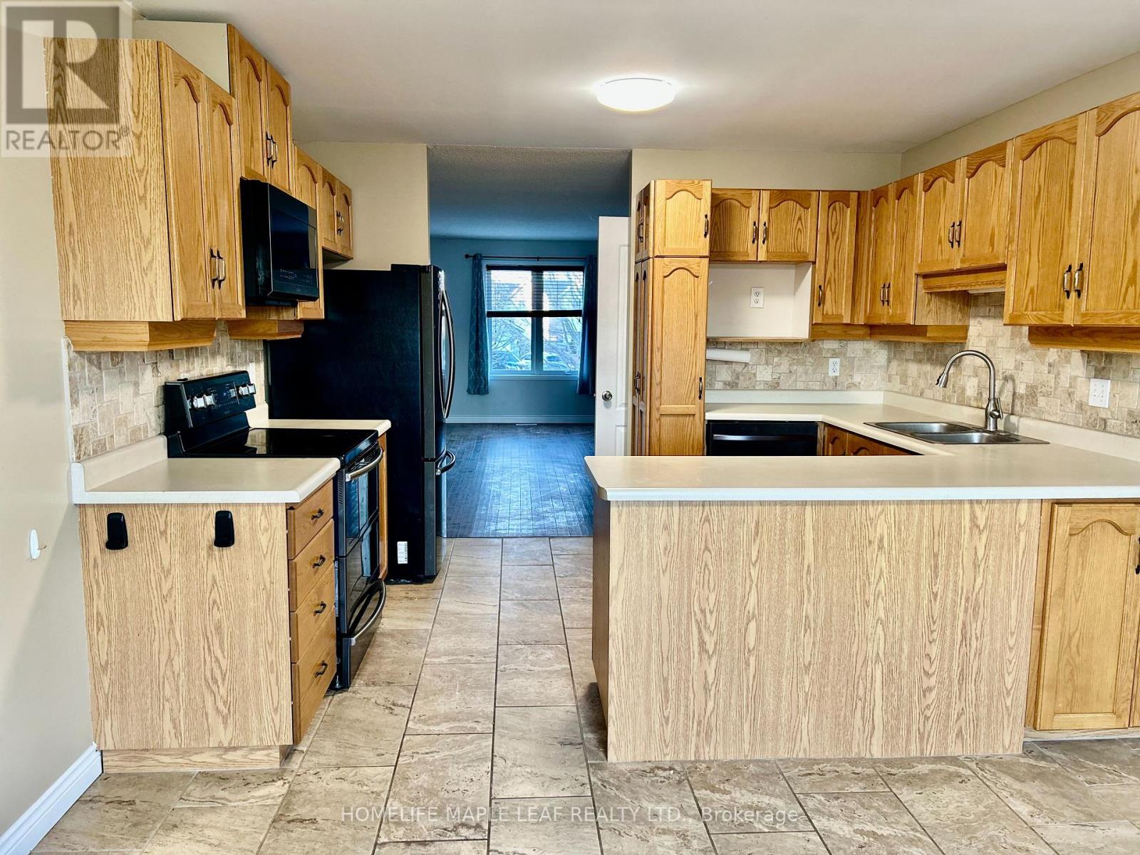 A kitchen with wooden cabinets and black appliances.