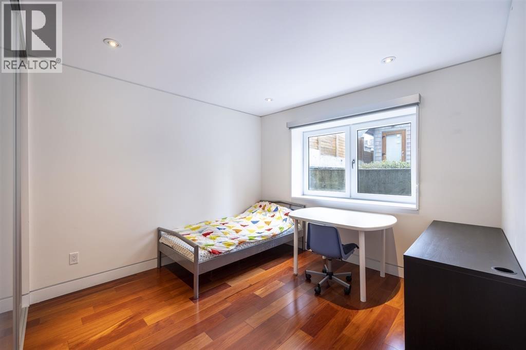 A bedroom with a bed, desk, and chair.