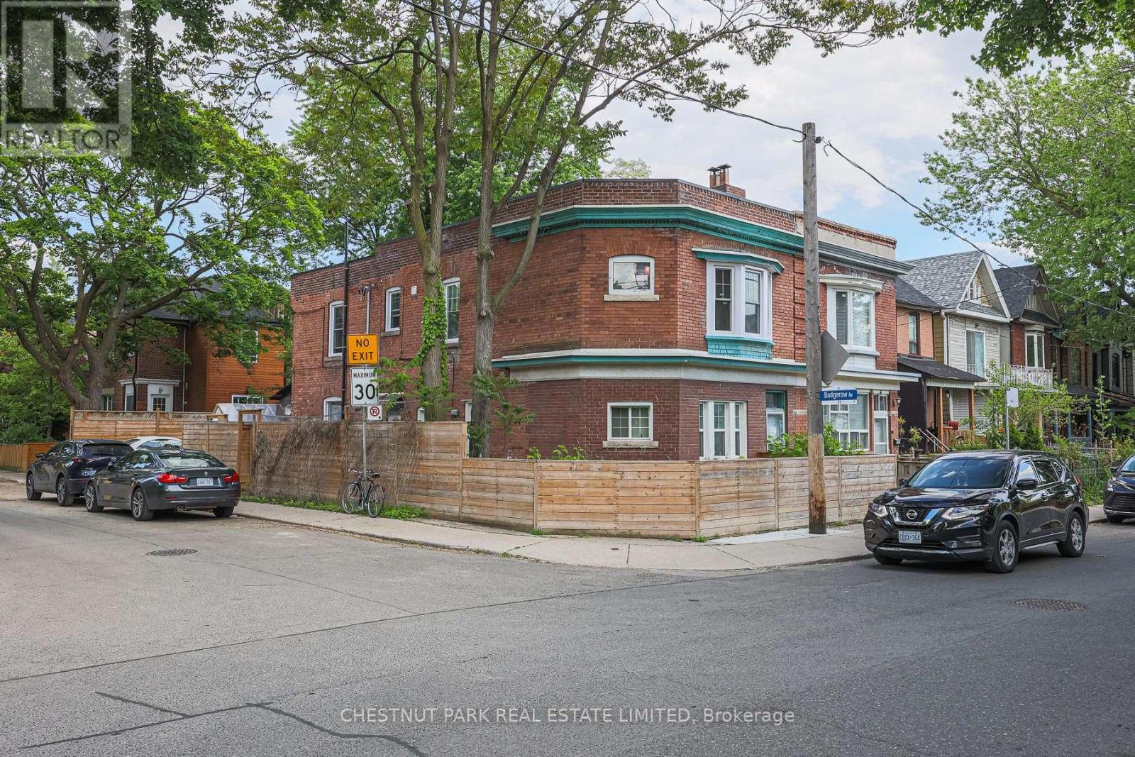 A brick house with a green trim and a sign that says 30.