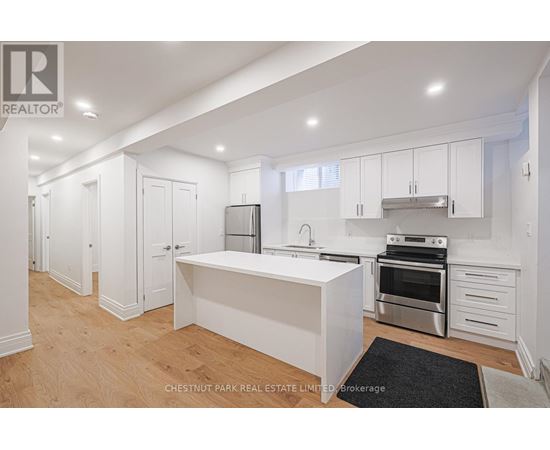 A modern kitchen with white cabinets and stainless steel appliances.
