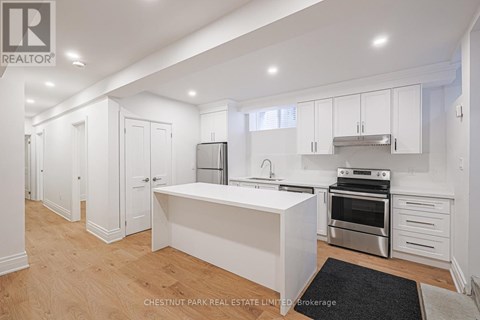 A modern kitchen with white cabinets and stainless steel appliances.
