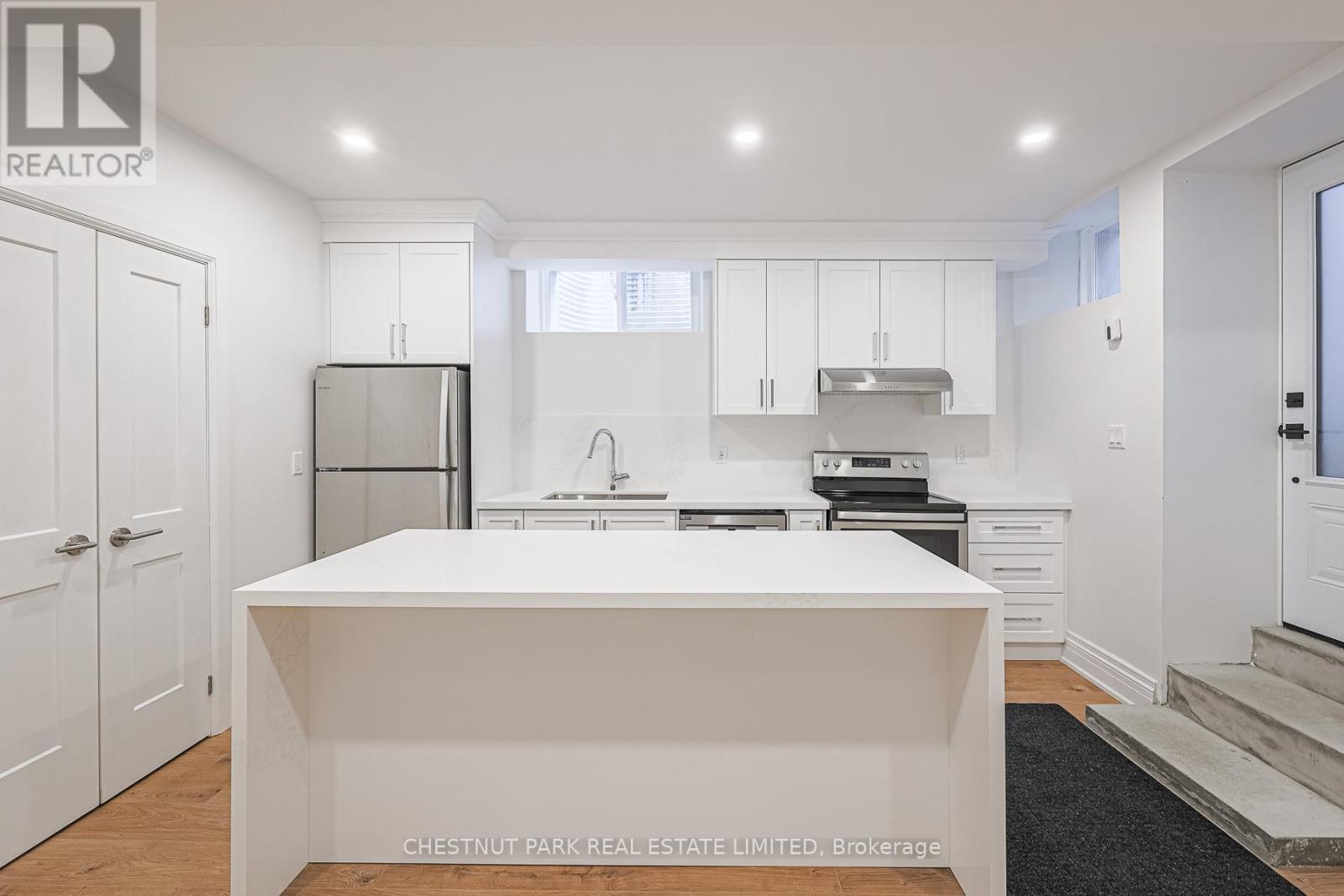 A white kitchen with a large island in the middle.