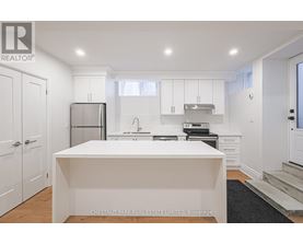 A white kitchen with a large island in the middle.