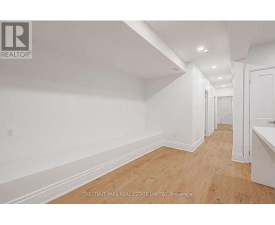 A long hallway with wood floors and white walls.