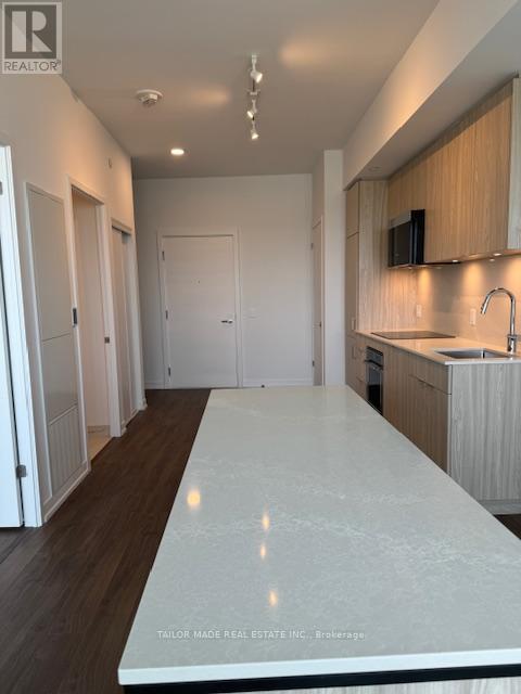 A kitchen with a white countertop and wooden cabinets.