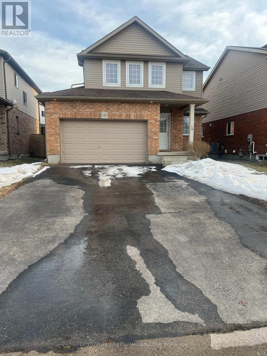 A house with a garage and a driveway in front of it.