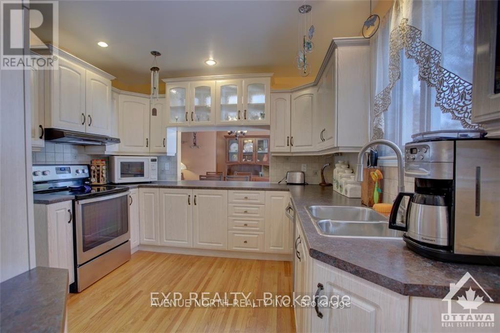 A kitchen with white cabinets and a wooden floor.