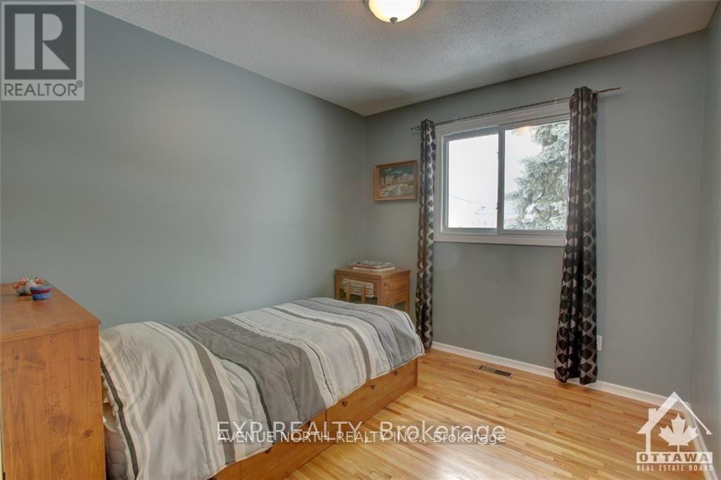 A bedroom with a bed, nightstand, and window.