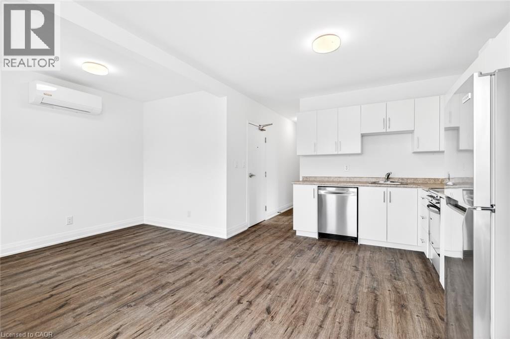 A kitchen with white cabinets and a wooden floor.