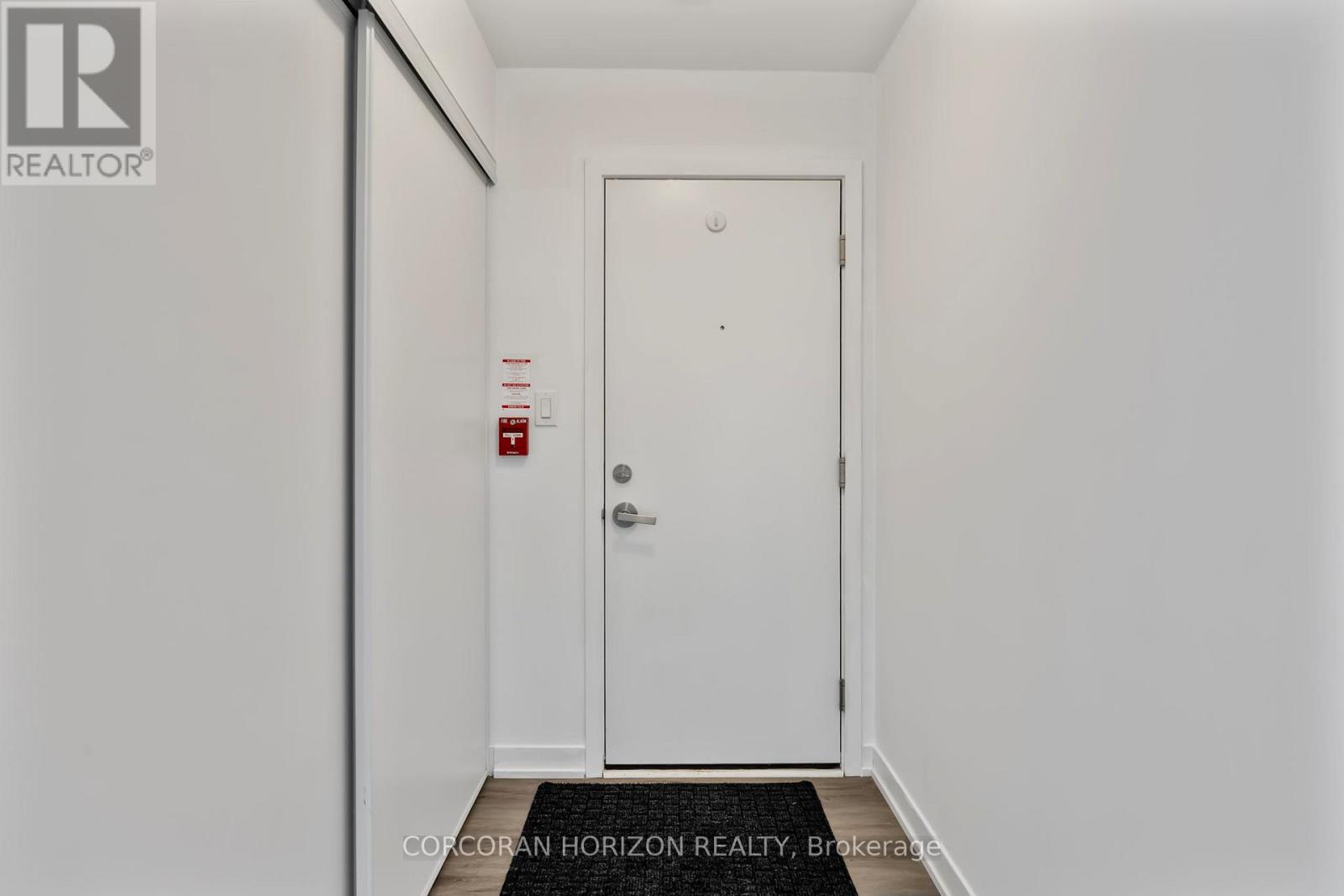 A white door with a fire extinguisher on the wall.