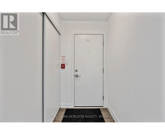 A white door with a fire extinguisher on the wall.