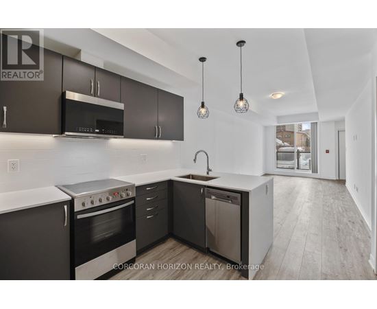 A modern kitchen with dark brown cabinets and stainless steel appliances.