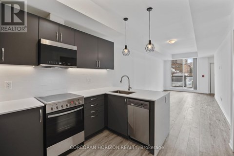 A modern kitchen with dark brown cabinets and stainless steel appliances.
