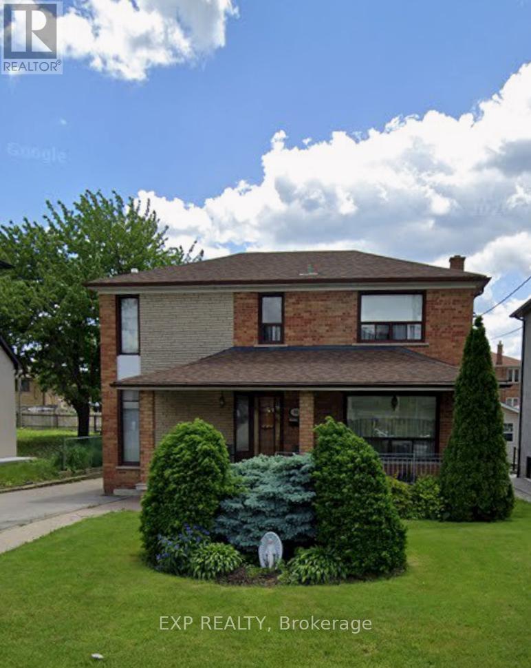 A house with a lawn and bushes in front of it.