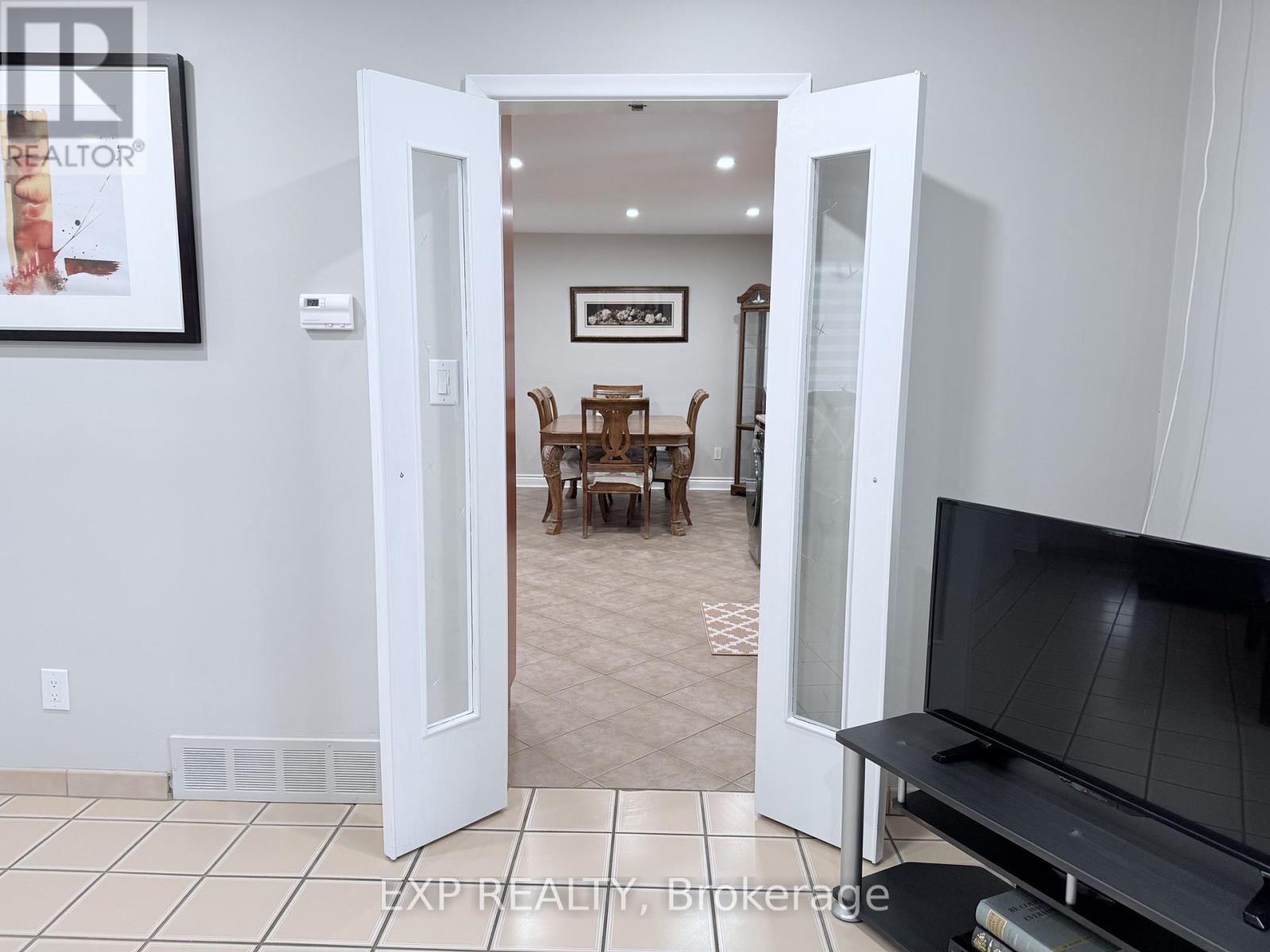 A living room with a television and a dining table.