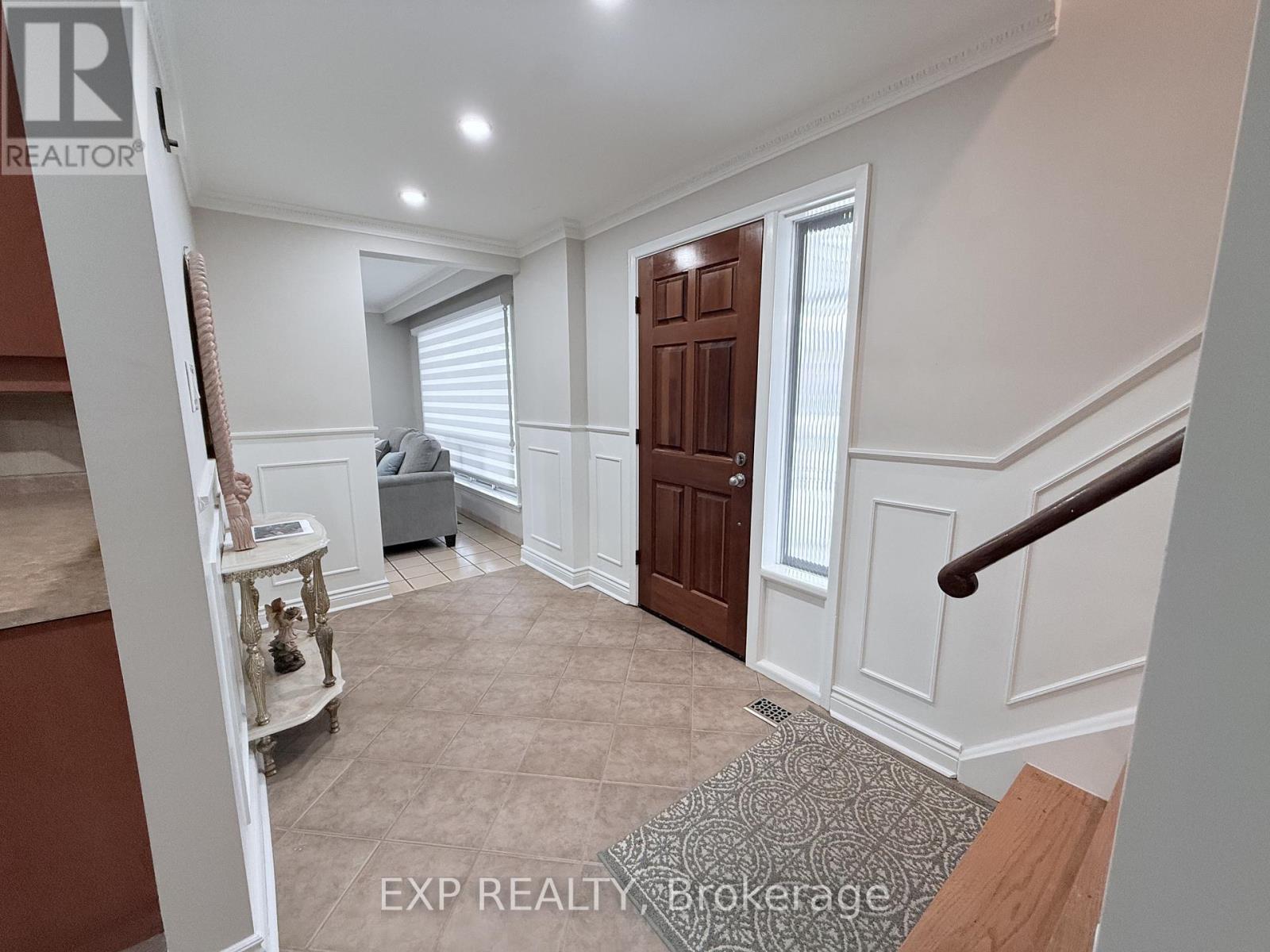 A hallway with a brown door and a carpeted floor.