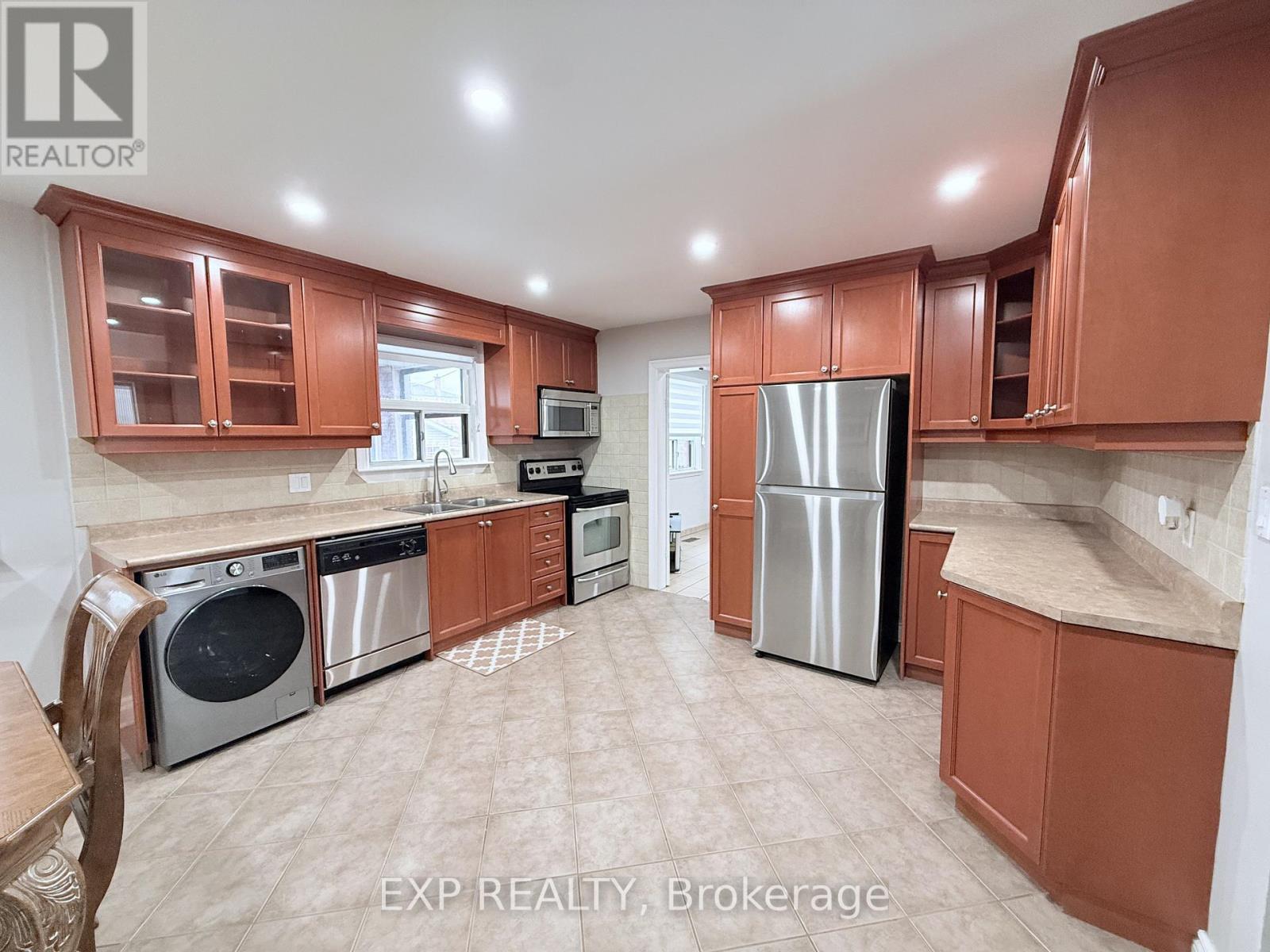 A kitchen with brown cabinets and stainless steel appliances.
