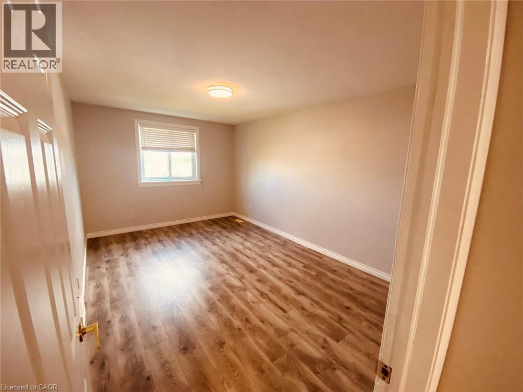A room with wooden flooring and a window.