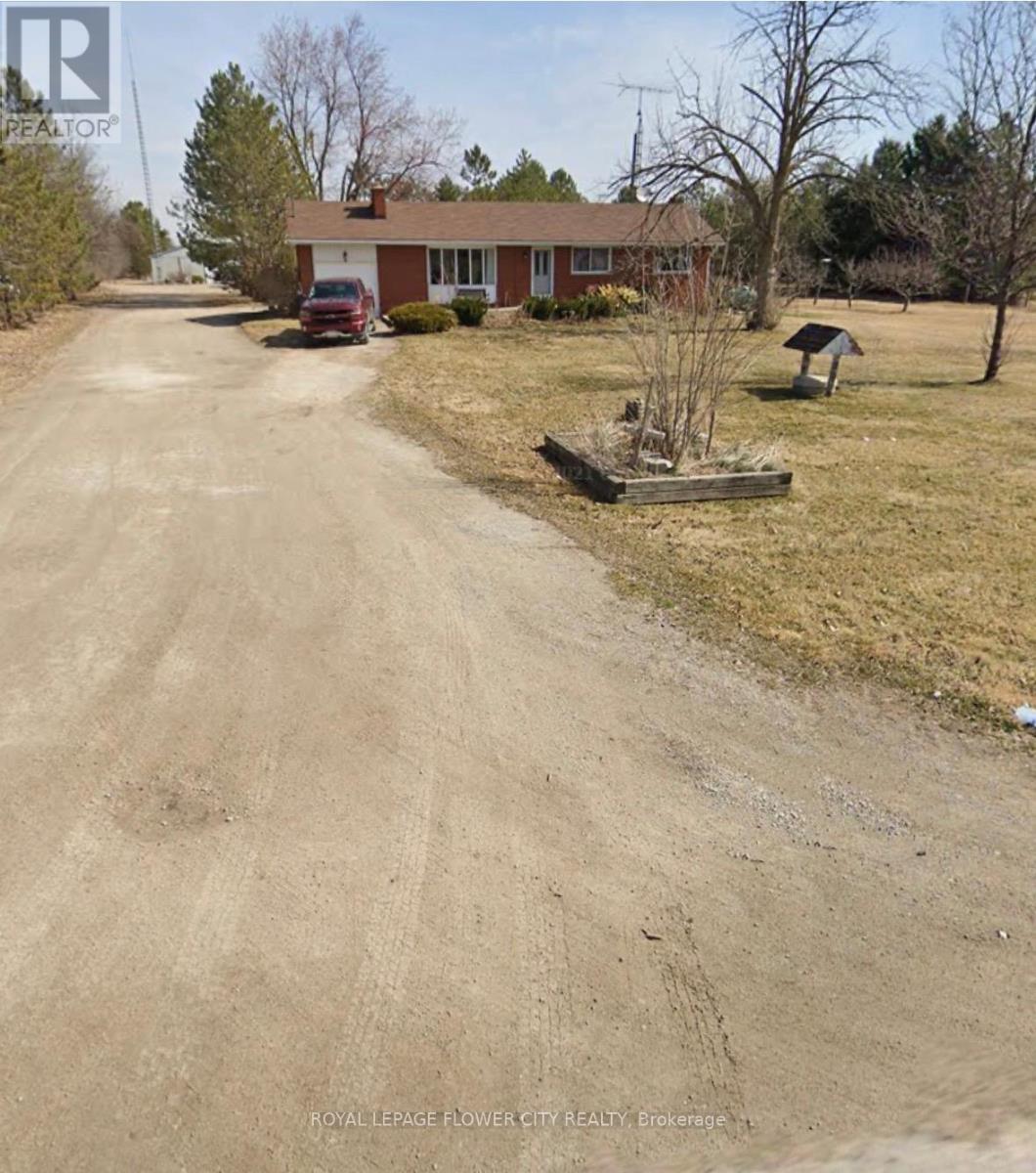 A dirt road leads to a house with a sign that says "Royal LePage Flower City Realty Brokerage.".