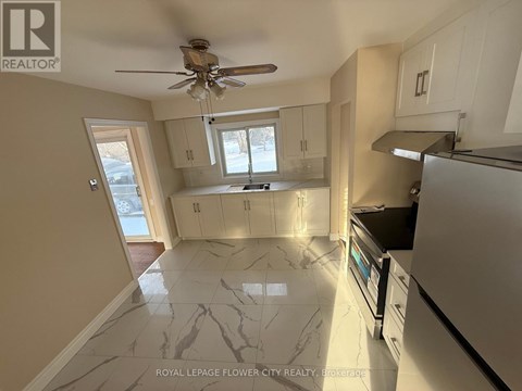 A kitchen with a marble floor and a ceiling fan.
