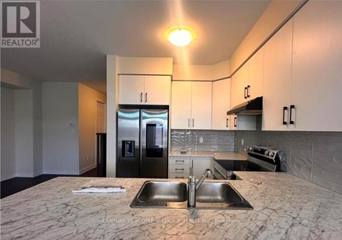 A kitchen with a sink and a refrigerator.
