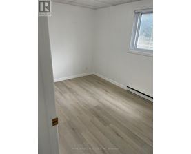 A room with a wooden floor and a window.