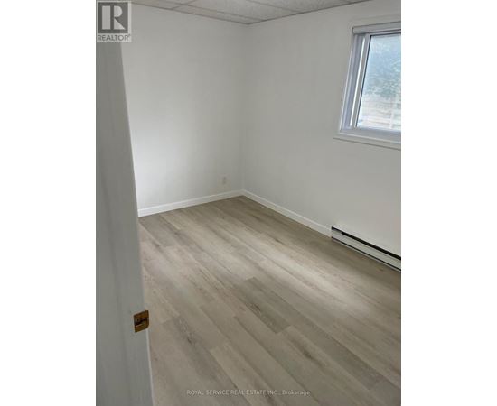 A room with a wooden floor and a window.