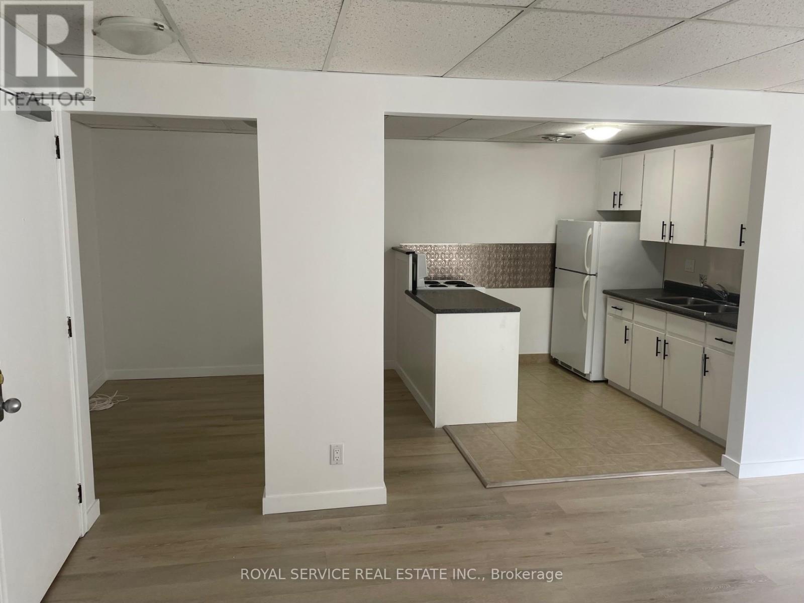 A kitchen area with white cabinets and a refrigerator.