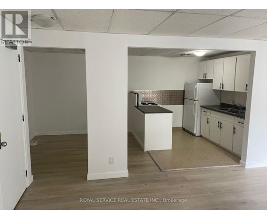 A kitchen area with white cabinets and a refrigerator.