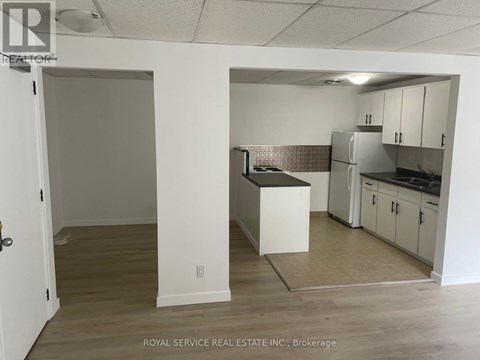 A kitchen area with white cabinets and a refrigerator.