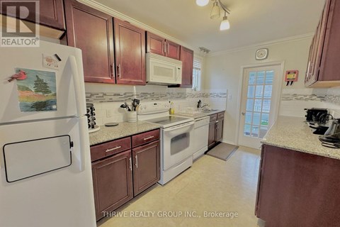A kitchen with brown cabinets and a white fridge.