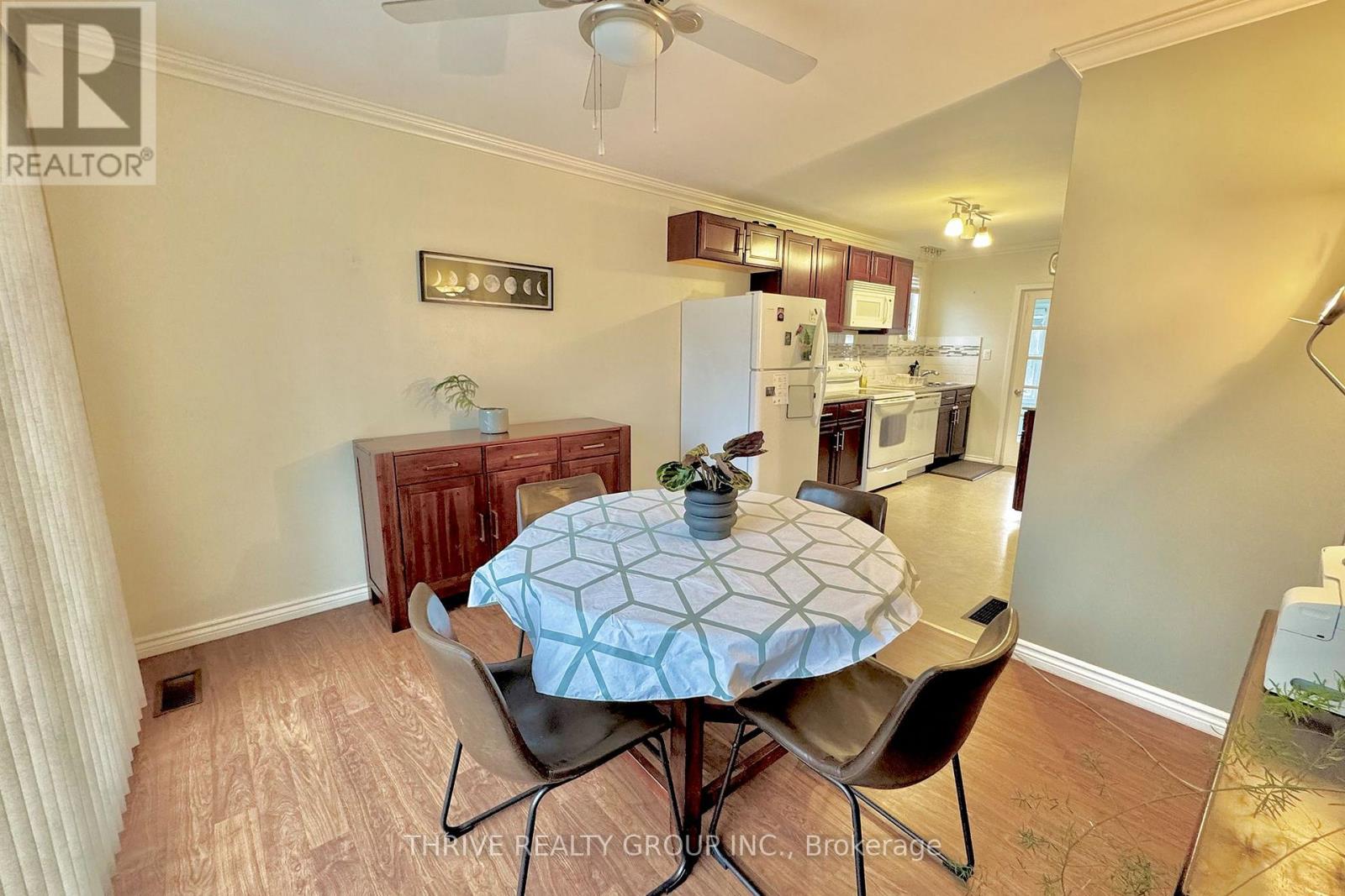 A dining room with a table set for two and a ceiling fan.