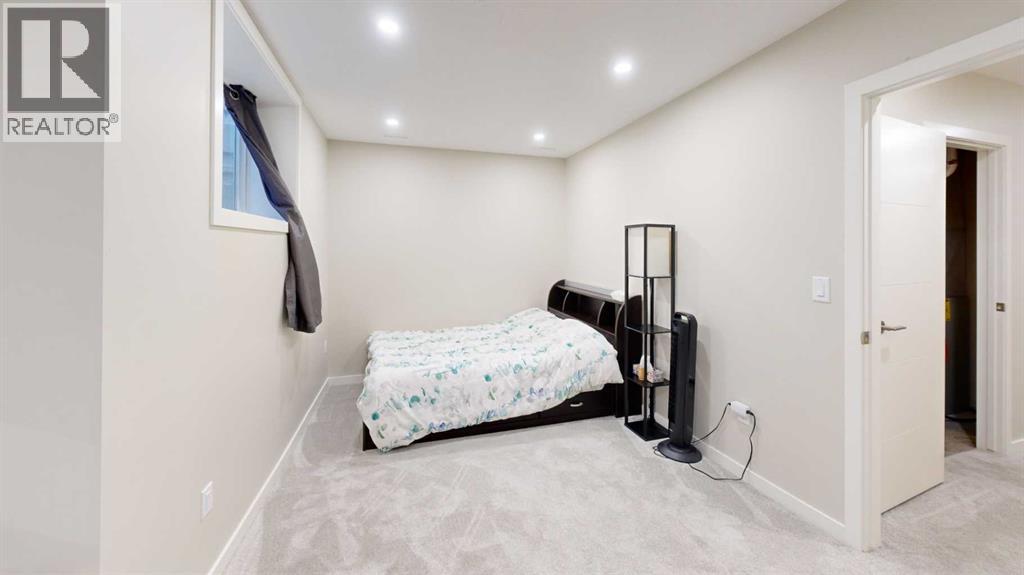 A bedroom with a bed, a chair, and a wall-mounted shelf.