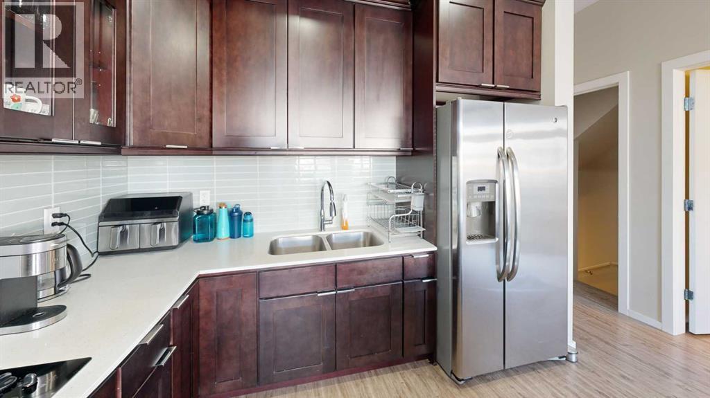 A kitchen with brown cabinets and a white fridge.