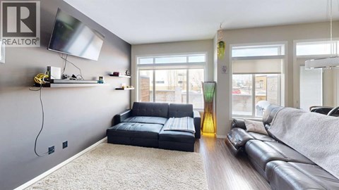 A living room with a black leather sofa and a grey couch.