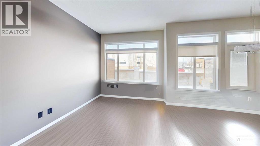 A spacious room with a large window and a wooden floor.