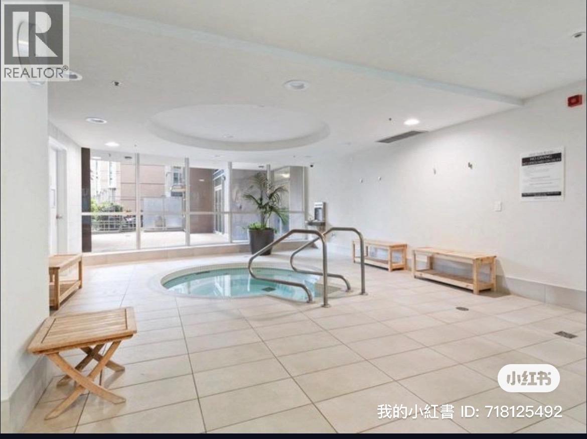 A large indoor swimming pool with a wooden bench and a glass door leading outside.