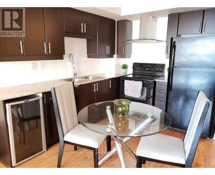 A kitchen with a table and chairs.