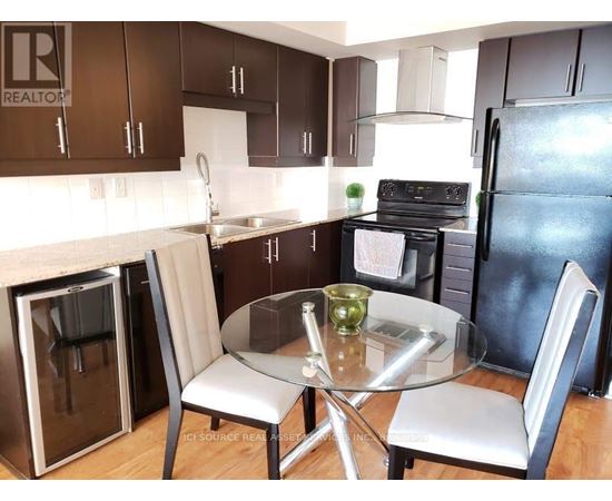 A kitchen with a table and chairs.
