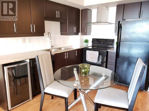 A kitchen with a table and chairs.