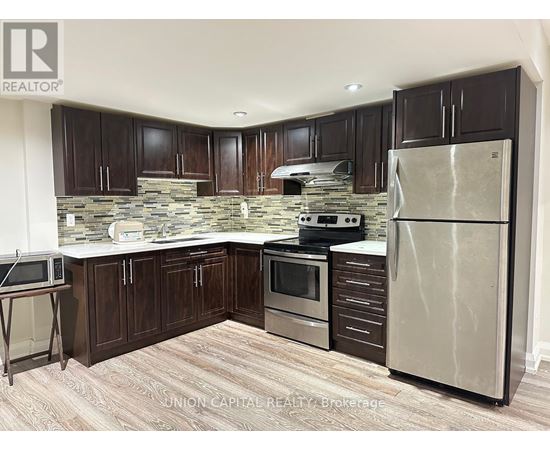 A kitchen with wooden cabinets and a stone backsplash.