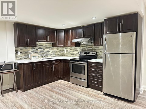 A kitchen with wooden cabinets and a stone backsplash.