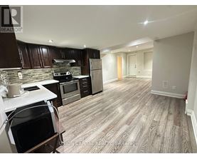 A kitchen with wooden cabinets and a stone backsplash.