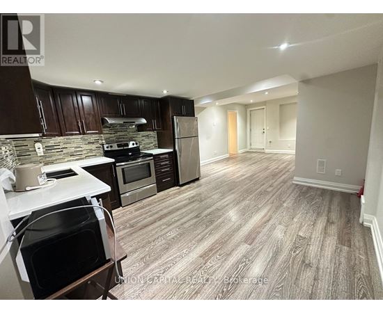 A kitchen with wooden cabinets and a stone backsplash.