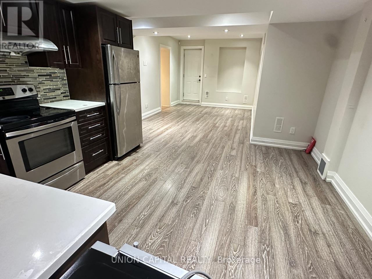 A kitchen with wooden flooring and a white counter top.
