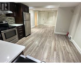 A kitchen with wooden flooring and a white counter top.